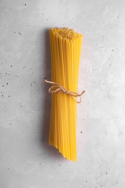 Rohe Spaghetti. Trockene italienische Pasta aus Hartweizen, grauer Hintergrund, Ansicht von oben