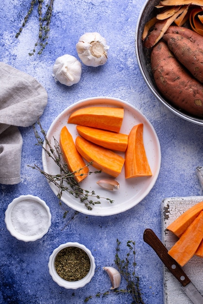 Foto rohe süßkartoffel mit kräutern und knoblauch