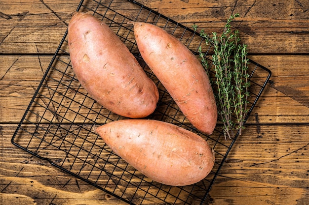 Rohe Süßkartoffeln auf Küchentisch frische Batata Hölzerner Hintergrund Ansicht von oben