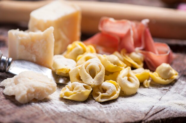 Rohe Tortellini auf rustikalem Holztisch