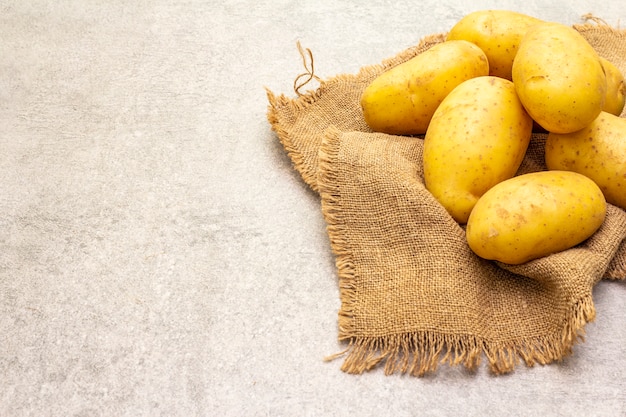 Rohe ungeschälte junge Kartoffeln auf Sackleinen