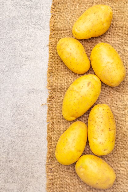 Rohe ungeschälte junge Kartoffeln auf Sackleinen