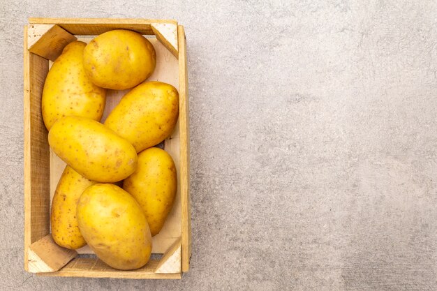 Rohe ungeschälte junge Kartoffeln in einer Holzkiste