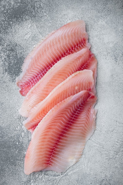 Foto rohe weiße fischfiletschnitte, auf grauem tisch, draufsicht