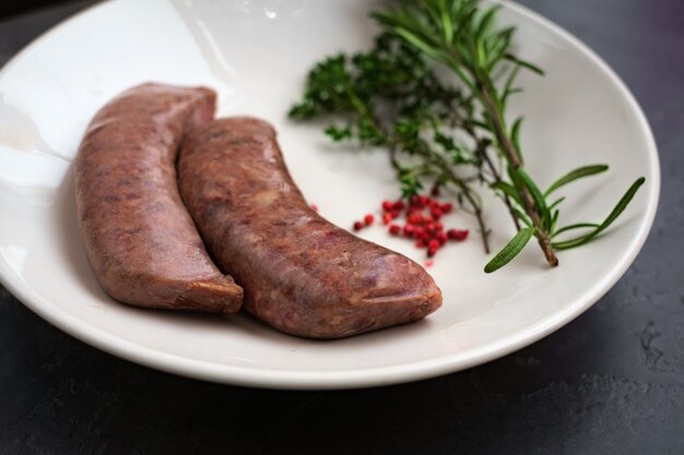 Foto rohe würste zum grillen auf einer platte