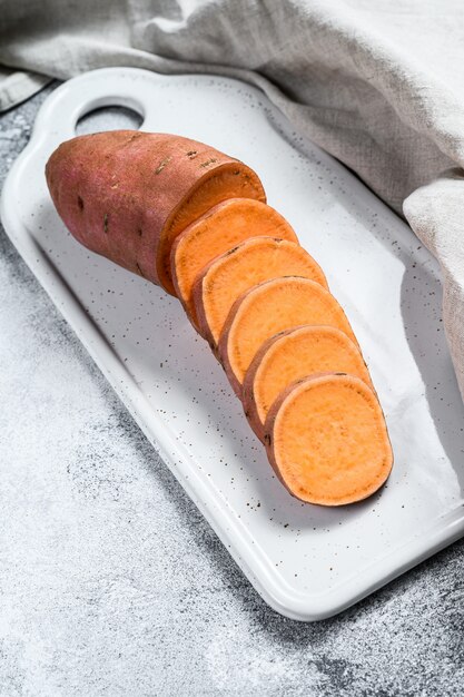 Rohe Yamswurzel auf einem Schneidebrett, organische Batatas