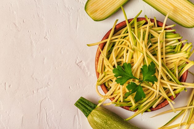 Rohe Zucchininudeln auf weißer Oberfläche