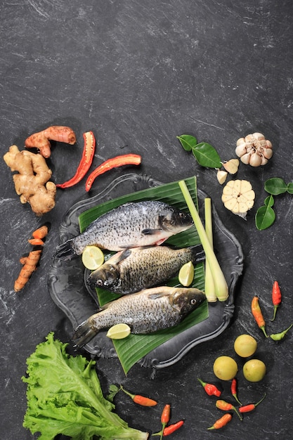 Rohe Zutaten von Pesmol Ikan Mas Goldfisch mit gelben Currygewürzen