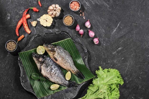 Rohe Zutaten von Pesmol Ikan Mas Goldfisch mit gelben Currygewürzen