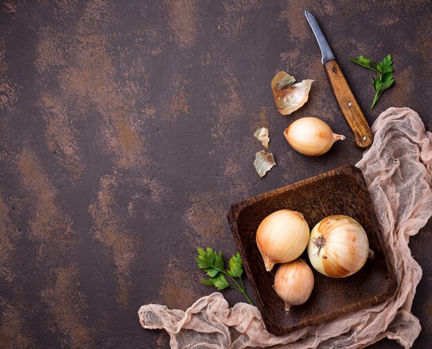 Rohe Zwiebeln auf rostigem Hintergrund