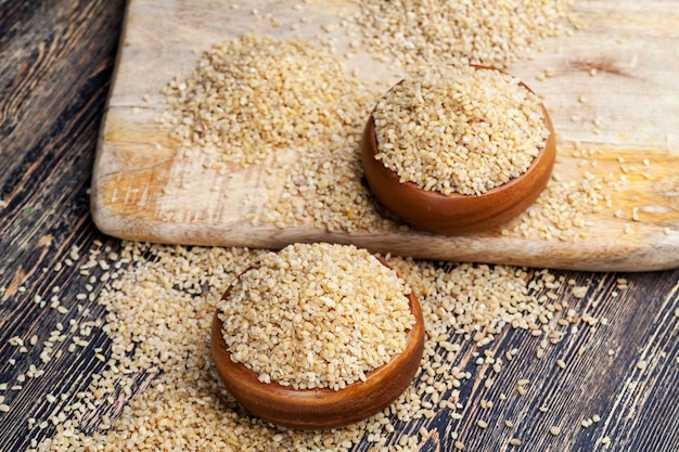 Roher Bulgurbrei, der nicht kocht, eine große Menge Getreide auf einem Holztisch, Bulgur wird aus Weizenkorn hergestellt