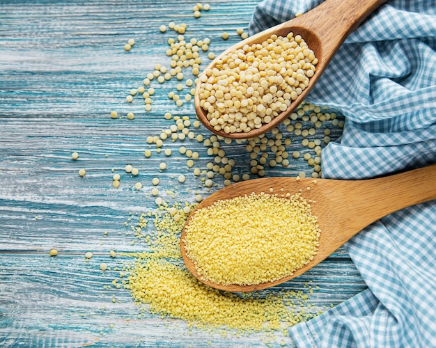 Roher Couscous in einem Holzlöffel auf dem Tisch