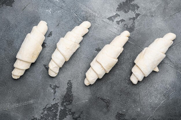 Foto roher croissant-teig auf grauem steintisch hintergrund draufsicht flach gelegt