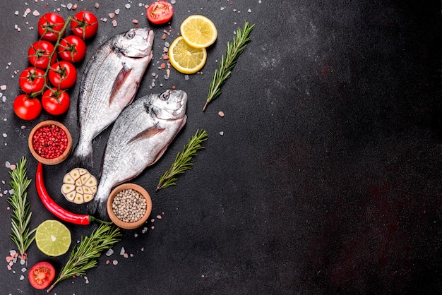 Roher Dorado-Fisch mit Gewürzen, die auf Schneidebrett kochen. Dorado mit frischem Fisch. Dorado und Zutaten zum Kochen auf einem Tisch