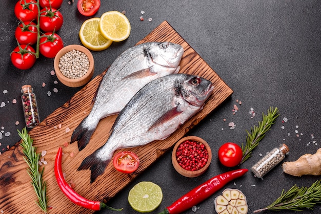 Roher Dorado-Fisch mit Gewürzen, die auf Schneidebrett kochen. Dorado mit frischem Fisch. Dorado und Zutaten zum Kochen auf einem Tisch