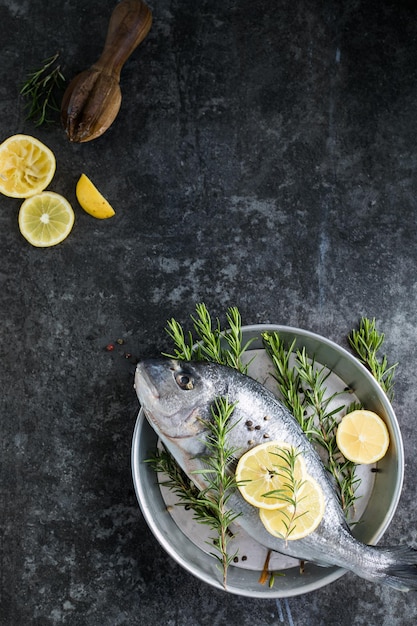 Roher Dorado-Fisch mit Gewürzen Dorado und Zutaten zum Kochen auf einem Tisch