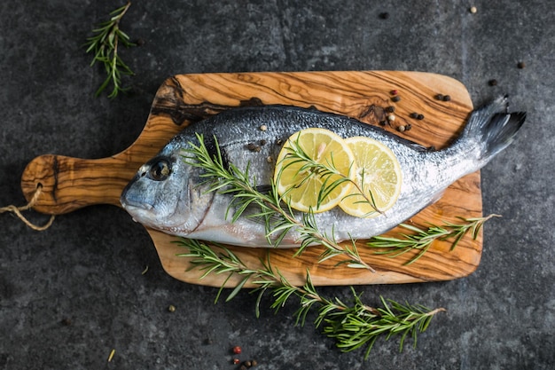 Roher Dorado-Fisch mit Gewürzen Dorado und Zutaten zum Kochen auf einem Tisch