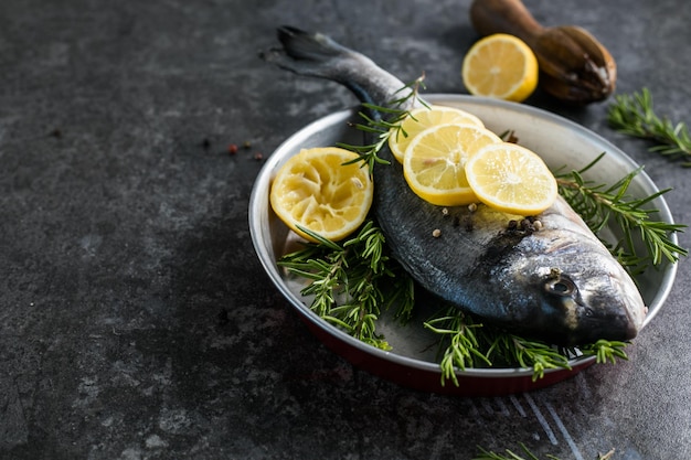 Roher Dorado-Fisch mit Gewürzen Dorado und Zutaten zum Kochen auf einem Tisch