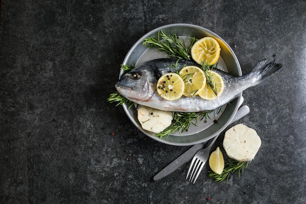 Roher Dorado-Fisch mit Gewürzen Dorado und Zutaten zum Kochen auf einem Tisch