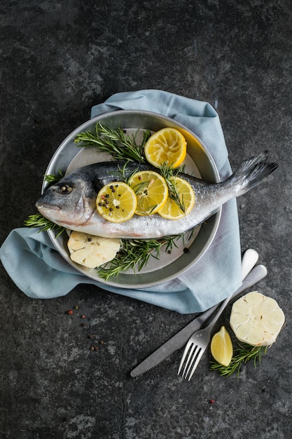 Roher Dorado-Fisch mit Gewürzen Dorado und Zutaten zum Kochen auf einem Tisch