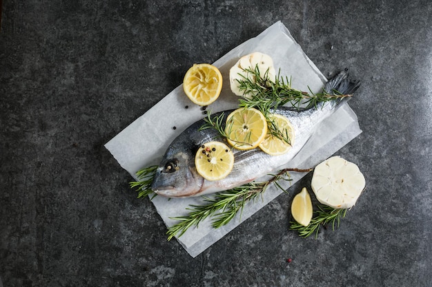 Roher Dorado-Fisch mit Gewürzen Dorado und Zutaten zum Kochen auf einem Tisch