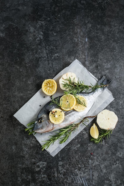 Roher Dorado-Fisch mit Gewürzen Dorado und Zutaten zum Kochen auf einem Tisch