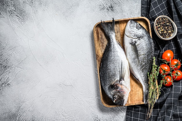 Roher Dorado-Fisch mit Kochzutaten, Kirschtomaten, Thymian, Pfeffer. Grauer Hintergrund