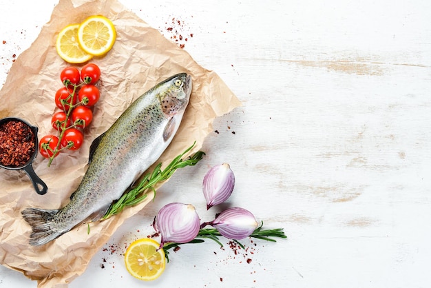 Roher Fisch auf weißem Holzhintergrund Fischforelle Draufsicht Freier Platz für Ihren Text