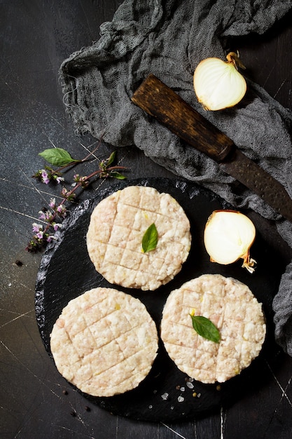 Roher frischer Schnitzel-Burger vom Rind für hausgemachte Burger, die mit Gewürzen kochen Ansicht von oben