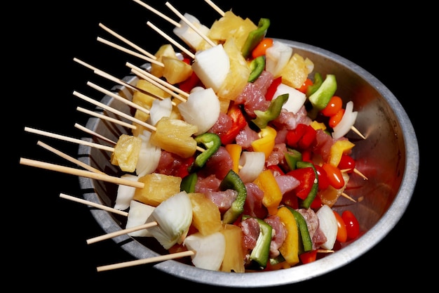 Roher Kebab aus Fleisch auf einem hölzernen Hintergrund mit Gemüse auf schwarzem Hintergrund