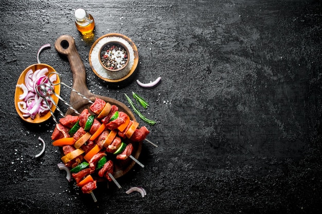 Roher Kebab mit Gemüse, Gewürzen, Öl und geschnittenen Zwiebeln in einer Schüssel