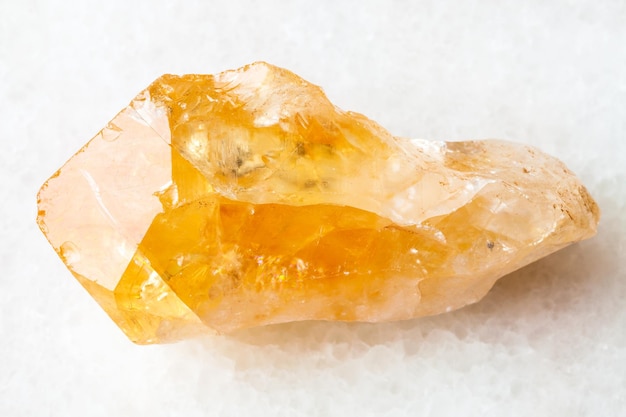 Foto roher kristall aus citrin-edelstein auf weiß