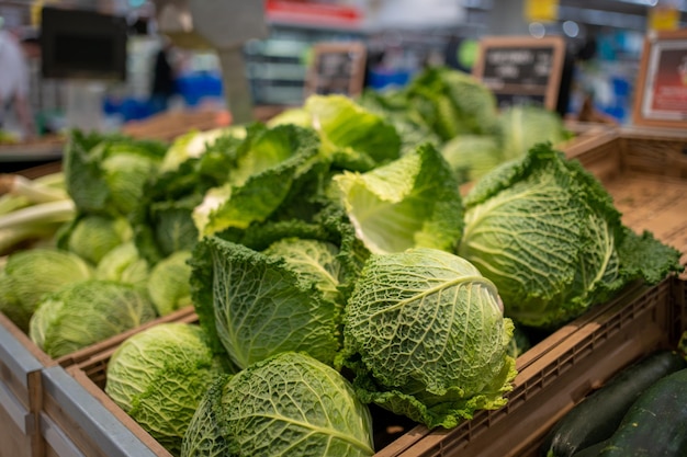 Roher saftiger Kohl im Plastikkorb auf dem Regal im Supermarkt