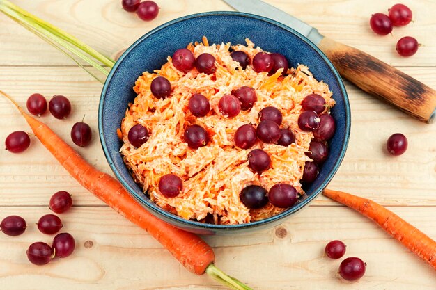 Foto roher salat aus geriebenen karotten und stachelbeeren in einer schüssel