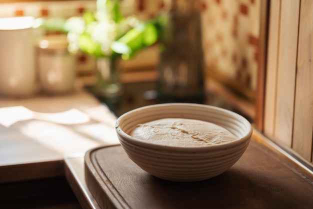 Roher Teig zum Backen von Brot in einer beigen runden Schüssel. Teig in Form von zukünftigem selbstgebackenem Brot