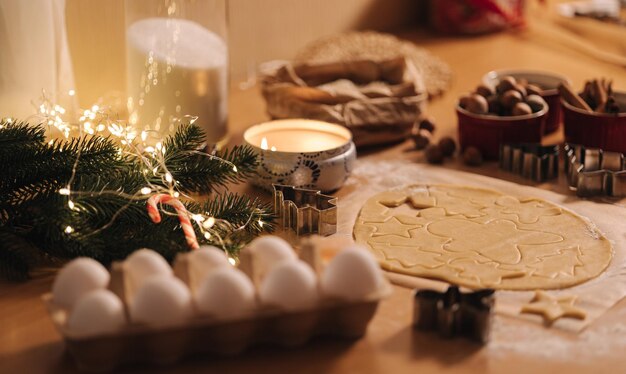 Roher Teig zum Kochen von Weihnachtsplätzchen Lebkuchen auf Holztisch Kerzenlicht am Abend