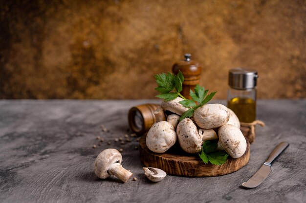 Foto roher weißer pilz, champignons und pfeffer auf grauem hintergrund zum kochen von frischen zutaten