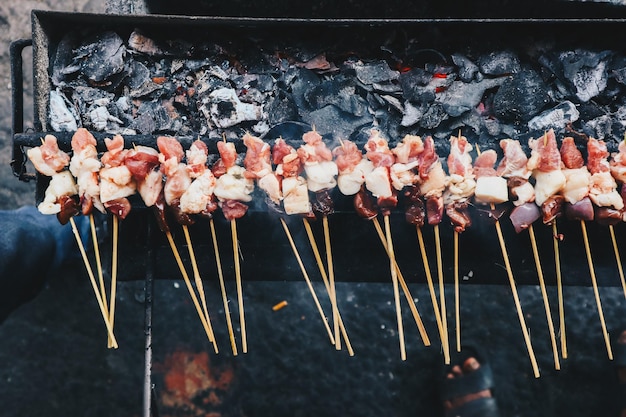 Roher Ziegen-Satay Lamm-Satay Lamm oder Fleisch-Ziegen-Satay am Grillplatz mit Feuer und Rauch Traditioneller Satay aus Java Indonesien