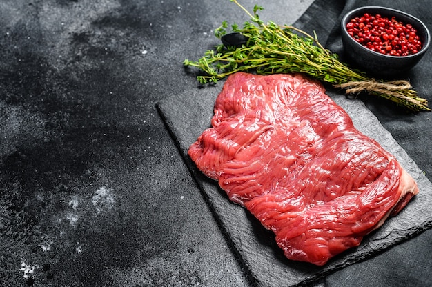 Rohes Außenrocksteak, marmoriertes Fleisch. Schwarzer Hintergrund. Draufsicht. Speicherplatz kopieren.