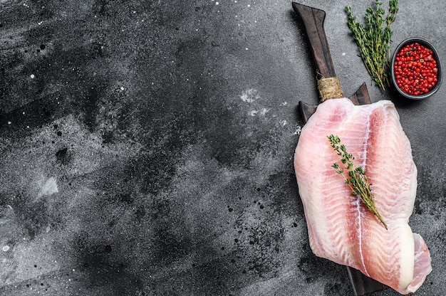 Rohes Filet des Weißfischwelses auf einem Schneidebrett.