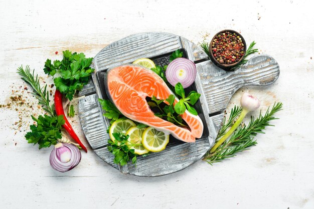 Rohes Fischsteak mit Petersilie und Zitrone auf dem Tisch Lachs Draufsicht Freier Platz für Ihren Text Rustikaler Stil