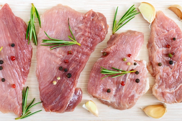 Rohes flaches Fleisch für Steak (Kotelett) mit Gewürzen auf einem Leuchttisch. Draufsicht.