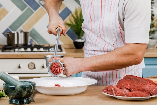 Rohes Fleisch Die Zubereitung von Hackfleisch erfolgt mit einem Fleischwolf