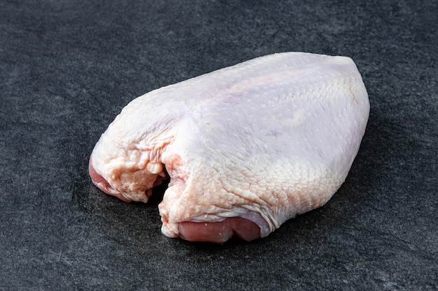 Rohes Fleisch Huhn liegt auf einer Steinplatte ohne Dekoration