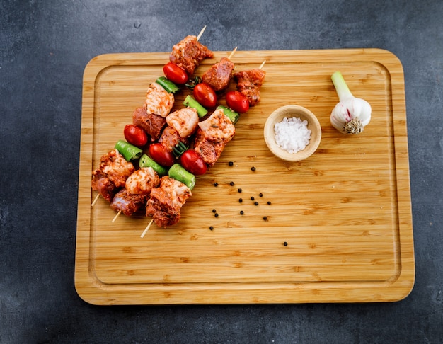 Rohes Fleisch Kebab Knoblauch und Salz auf dem Holz und dunklem Hintergrund