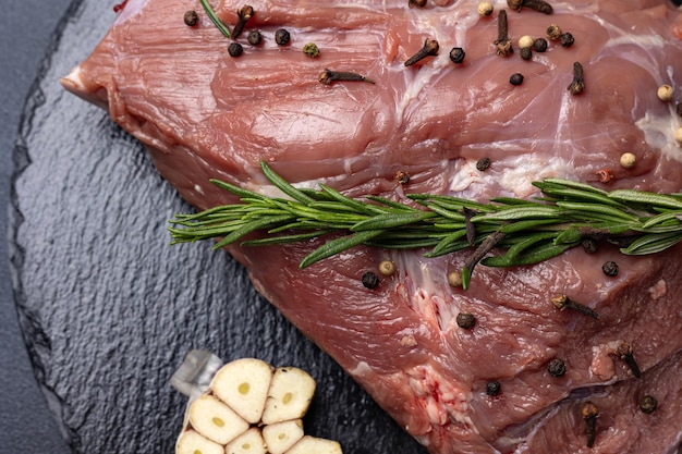 rohes Fleisch mit Gewürzen auf dunklem Hintergrund