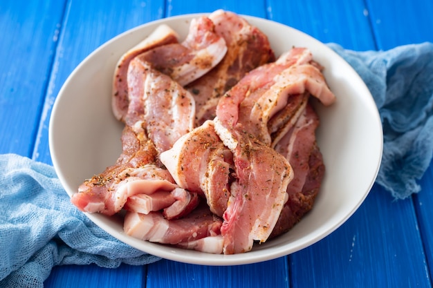 Rohes Fleisch mit Kräutern und Knoblauch zum Grillen auf Teller