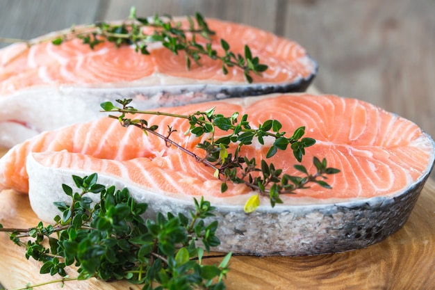 Rohes, frisches Lachssteak auf einem Brett und Gewürze herum. Roter Lachs roter Fisch. Lachs kochen, Meeresfrüchte. Gesundes Lebensmittelkonzept. Lachs und Gewürze