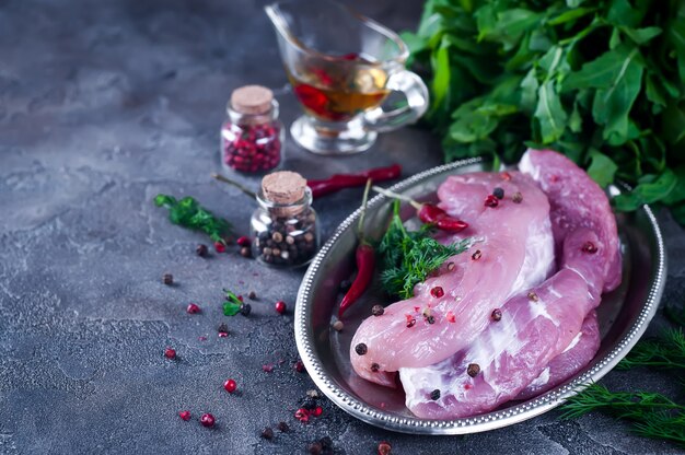 Rohes Frischfleischsteak entrecote und Gewürze in der Eisenplatte mit Öl, Paprika, Gewürzdill