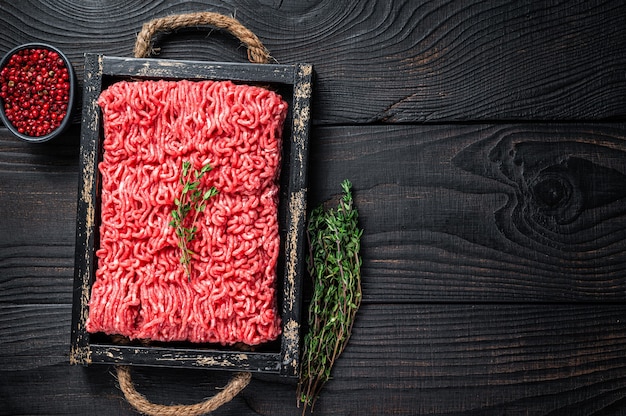 Rohes Hackfleisch Rind- und Schweinefleisch in einem Holztablett mit Kräutern